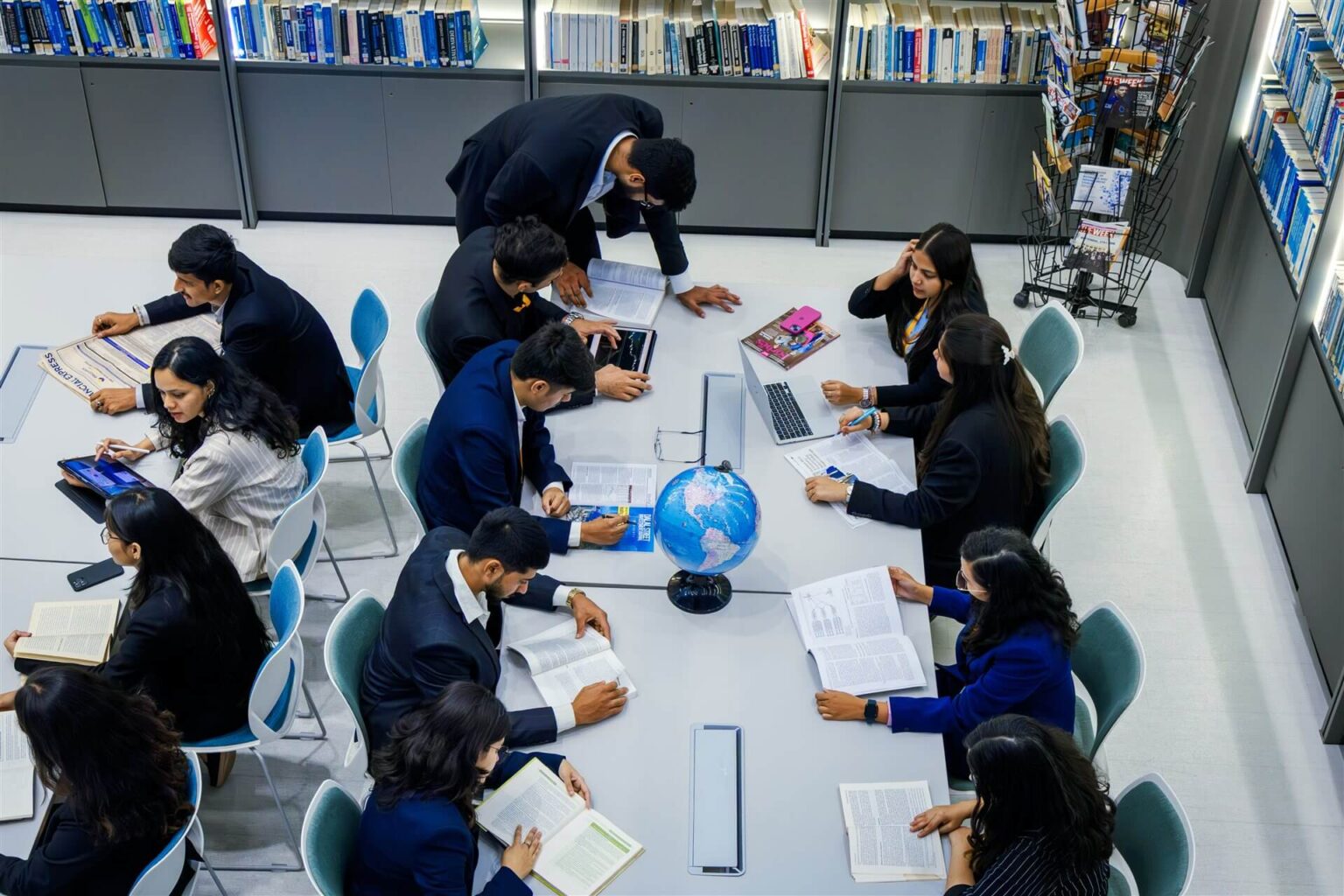 ISBR PGDM students working together around a globe in the campus library